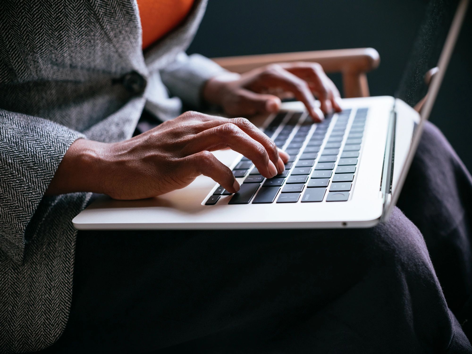 Close-up of professional typing on laptop to represent chatbot FAQ automation